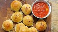 Cheese-stuffed garlic dough balls with a tomato sauce dip Cheese-stuffed garlic dough balls with a tomato sauce dip