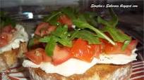 Bruschetta de queijo, tomate e rúcula Bruschetta de queijo, tomate e rúcula