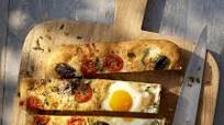 Breakfast focaccia baked with eggs, herbs, cherry tomatoes and parmesan Breakfast focaccia baked with eggs, herbs, cherry tomatoes and parmesan