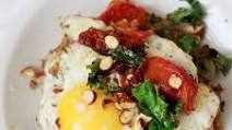Breakfast potato latke topped with egg, kale, tomatoes, and tamari almonds Breakfast potato latke topped with egg, kale, tomatoes, and tamari almonds