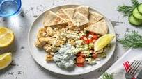 Assiette souvlaki poulet & tzatziki maison avec une salade grecque et un pain pita Assiette souvlaki poulet & tzatziki maison avec une salade grecque et un pain pita