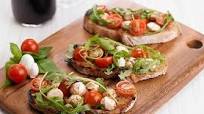Bruschetta de tomate-cereja, mozzarela e manjericão Bruschetta de tomate-cereja, mozzarela e manjericão