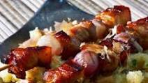 Marinated pork belly skewers on an Asian potato salad Marinated pork belly skewers on an Asian potato salad