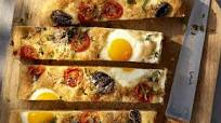 Breakfast focaccia baked with eggs, herbs, cherry tomatoes and parmesan Breakfast focaccia baked with eggs, herbs, cherry tomatoes and parmesan
