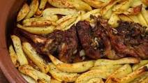 Roast goat with potatoes and lemon in the wood fired oven Roast goat with potatoes and lemon in the wood fired oven