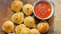 Cheese-stuffed garlic dough balls with a tomato sauce dip Cheese-stuffed garlic dough balls with a tomato sauce dip