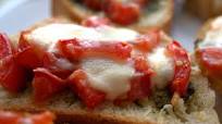 Bruschettas italianas com tomates, azeitonas pretas e parmesão Bruschettas italianas com tomates, azeitonas pretas e parmesão