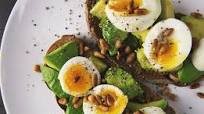 Tosta de pan de centeno, huevos de Corral, aguacate y piñones Tosta de pan de centeno, huevos de Corral, aguacate y piñones