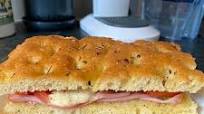 Focaccia bread with Mortadella, grilled tomatoes, melted mozzarella and cornichons Focaccia bread with Mortadella, grilled tomatoes, melted mozzarella and cornichons